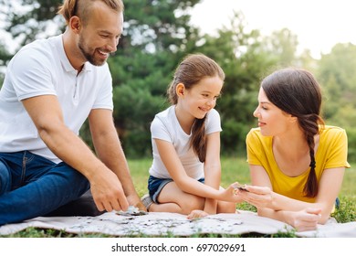 Happy Family Doing Puzzle On Picnic