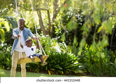 Happy family doing swing at park - Powered by Shutterstock