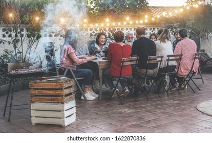 Happy Family Eating At Barbecue Party Dinner - Different Age Of People Having Fun At Bbq Meal Sitting In Villa Backyard - Summer Lifestyle And Food Concept - Main Focus On Left Asian Woman Face