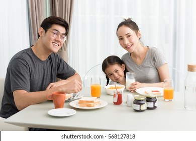 Happy Family Eating Breakfast In Kitchen Together At Home.