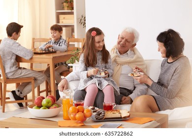 Happy Family Eating A Cake In A Living Room