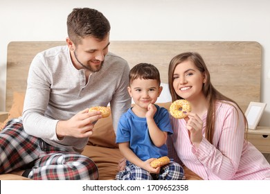 Happy Family Eating Donuts In Bedroom