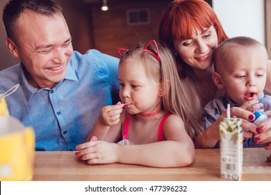 Happy Family Eating Fast Food In Restaurant All Together