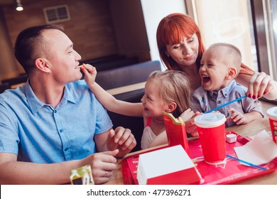 Happy Family Eating Fast Food In Restaurant All Together