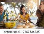 Happy family, eating and food with laughing outdoor on patio with funny conversation, bonding and healthy lunch. People, dinner and relax at dining table in backyard of home with supper and talking