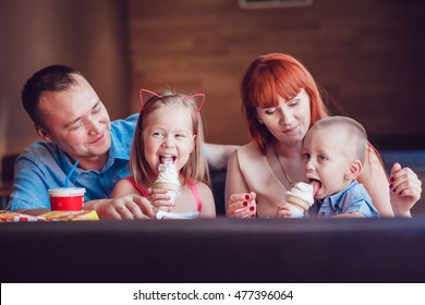 Happy Family Eating Ice Cream In Restaurant