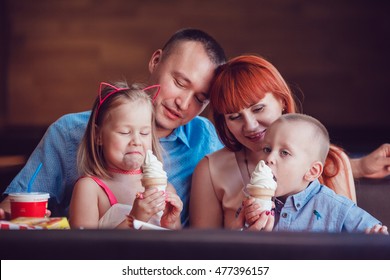 Happy Family Eating Ice Cream In Restaurant