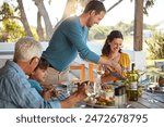 Happy family, eating and lunch with laughing outdoor on patio with funny people, bonding or healthy food. Parents, grandparents and kids at dining table in backyard of home with love or talking