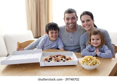 Happy Family Eating Pizza And Fries At Home