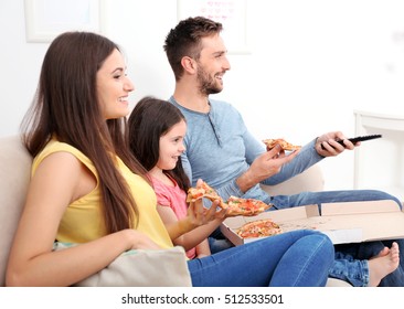 Happy Family Eating Pizza And Watching TV At Home