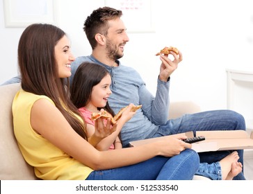 Happy Family Eating Pizza And Watching TV At Home