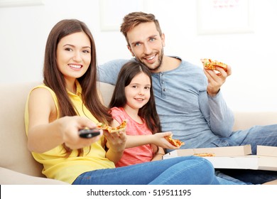 Happy Family Eating Pizza And Watching TV At Home