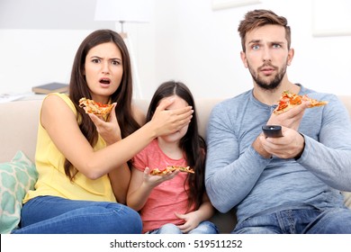 Happy Family Eating Pizza And Watching TV At Home