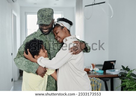 Happy family embracing their father, they meeting him from military service