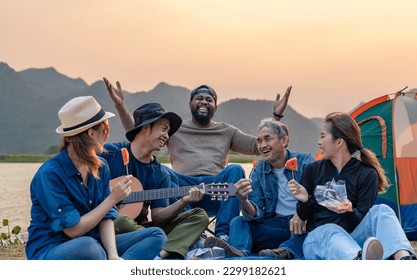 happy family enjoy singing songs playing music outdoor camping area with the mountain and river beauty in nature, diverse friends travelers spend time together during holiday vacation trip - Powered by Shutterstock