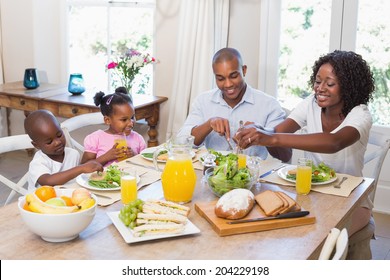 Happy Family Enjoying A Healthy Meal Together At Home In The Kitchen