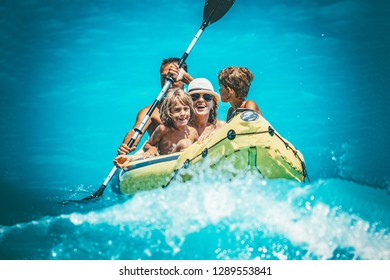 Happy Family Is Enjoying Paddling In Yellow Kayak At Tropical Ocean Water During Summer Vacation.They Are Kayaking On The Sea.