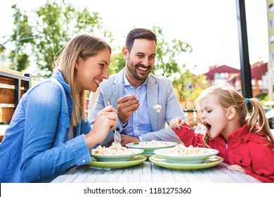 Happy Family Is Enjoying Pasta In Restaurant.