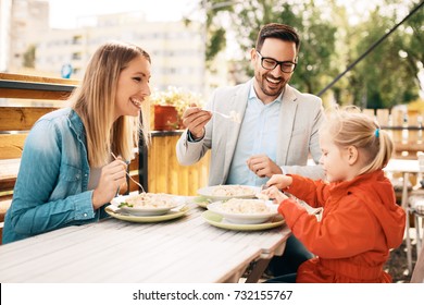 Happy Family Is Enjoying Pasta In Restaurant.