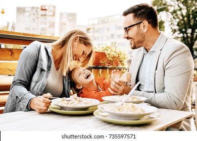Happy Family Is Enjoying Pasta In Restaurant.