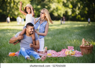 Happy Family Enjoying Picnic In Nature