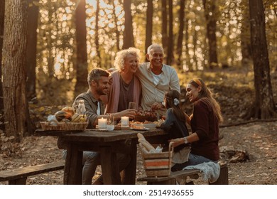 Happy family enjoying picnic in the woods while eating grapes and laughing on a beautiful sunny day - Powered by Shutterstock