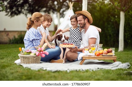Happy family enjoying summer together at backyard and eat pie.