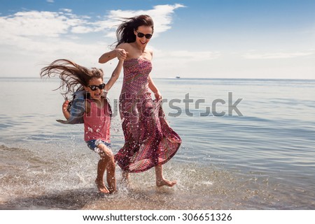Happy family enjoying sunny day at the beach. Mother and daughter