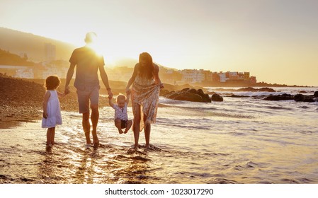 Happy family enjoying sunset in the summer leisure