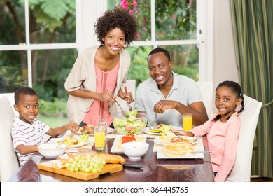 Happy Family Enjoying Their Meal At The Dinner Table