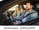 Happy family enjoying trip together by car, view from outside