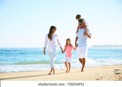 Happy Family Enjoying Walk On The Beach