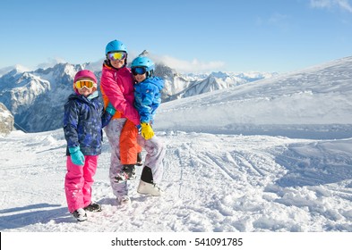 Happy Family Enjoying Winter Vacations In Mountains . Ski, Sun, Snow And Fun.