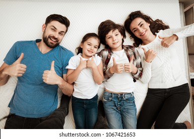 Happy Family Enjoys Comfort Of Lying On A Mattress Inside A Furniture Store. The Best Choice Of Orthopedic Mattress. Big Family Together Check Softness Of Mattress.