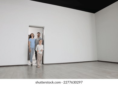 Happy family entering in their new apartment on moving day. Space for text - Shutterstock ID 2277630297