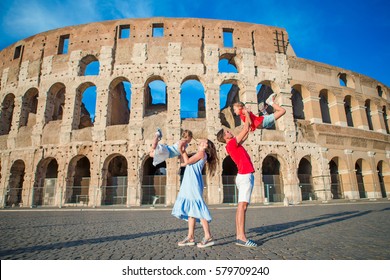 Happy Family In Europe. Parents And Kids In Rome Over Coliseum Background.