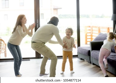Happy family with excited children playing hide and seek active game indoor, blindfolded father catching kids at home, parents and son daughter having fun together in country house on weekend leisure