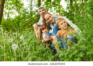 Happy family exploring together in green forest during summer vacation - Powered by Shutterstock