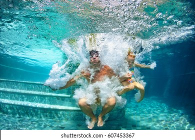 Happy family - father, baby daughter swim and dive in swimming pool with fun - jump deep down underwater with splashes. Lifestyle, summer children water sport activity and swimming lessons with parent