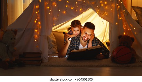 happy family father and child daughter  reading a book with a flashlight in a tent at home
 - Powered by Shutterstock