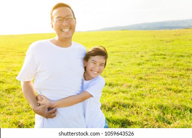 happy family father and child hugging on meadow