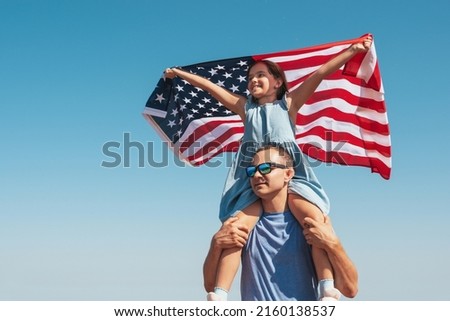 Happy family father and child with usa flag enjoy nature on sky background. Free lifestyle.
