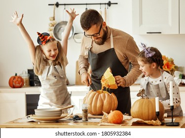 happy family   father  and children daughters prepare for Halloween by carving pumpkins at home in the kitchen - Shutterstock ID 1805932384