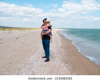 Happy Family Father Daughter Hugging On Marine Landscape. Bearded Dad With Child In Hands Having Fun Together Looking On Sea Water. Authentic Lifestyle Real People. Travel Fathers Day Southern Ukraine