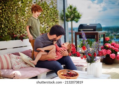 happy family, father and kids having fun, playing together on the rooftop patio on summer day - Shutterstock ID 2132073819