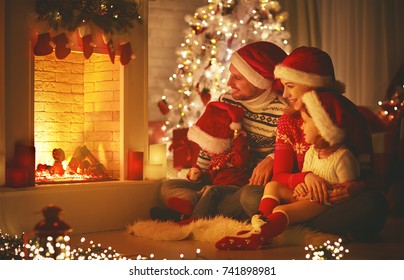 happy family father mother and children sitting by fireplace on Christmas Eve - Powered by Shutterstock