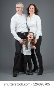 Happy Family Of Father, Mother And Daughter. Studio Shot.