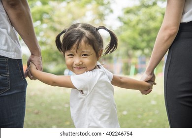 Happy family, Father, Mother and daughter holding hand in hand in garden.Asian, Asian family, picnic, love, relationship, outdoors meal, park, family activities or happy garden concept