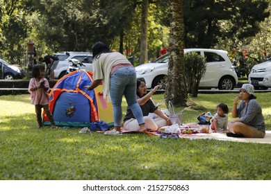 Happy Family, Father And Mother With One Small Girl And A Baby, Camping Together In A Tent In Outdoors Camp Site In The Nature. Real People. Copy Space. In Surabaya, Indonesia On May 5, 2022