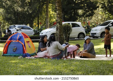 Happy Family, Father And Mother With One Small Girl And A Baby, Camping Together In A Tent In Outdoors Camp Site In The Nature. Real People. Copy Space. In Surabaya, Indonesia On May 5, 2022